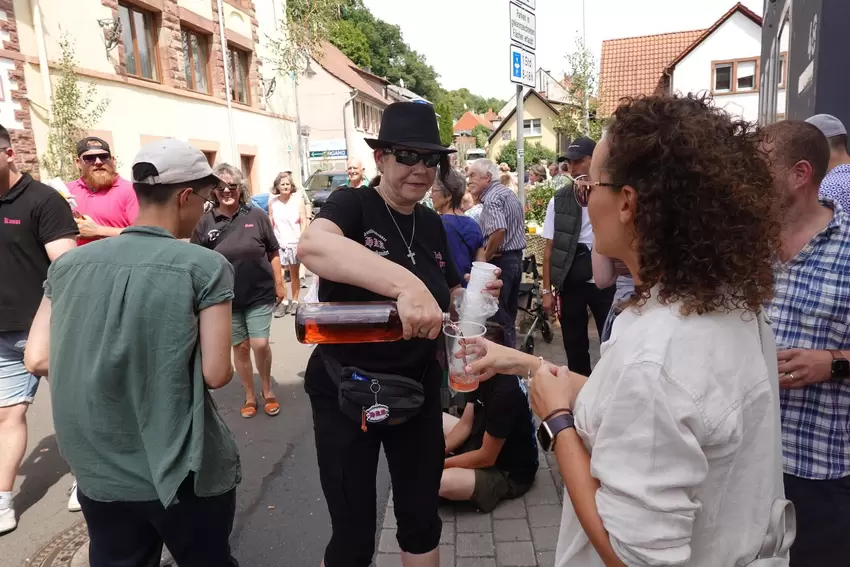 Beim Kerweumzug Altleiningen: Mitglied des Hertlingsheiser Kerwekomitees schenkt Wein aus.