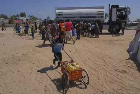 Palästinenser versuchen, ihren täglichen Wasserbedarf zu decken, indem sie Kanister aus Wassertankwagen füllen, die in das Gebie