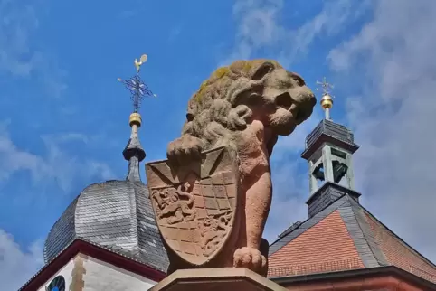 Steinerner Löwe über dem Wachenheimer Marktbrunnen, im Hintergrund die Kirche St. Georg.