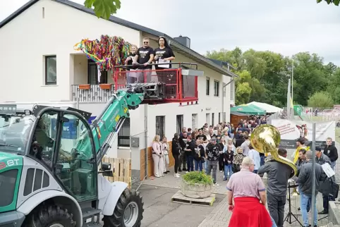 Nico Maio, Jennifer Kreis und Isabelle Frank lesen die Rede am Sportheim aus dem Radladerkorb. 