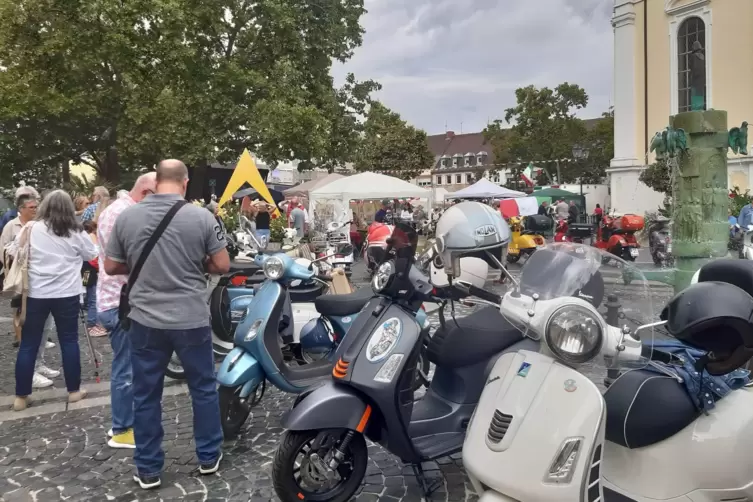 Markenzeichen Italiens: alte und neue Vespas vor dem Rathaus.