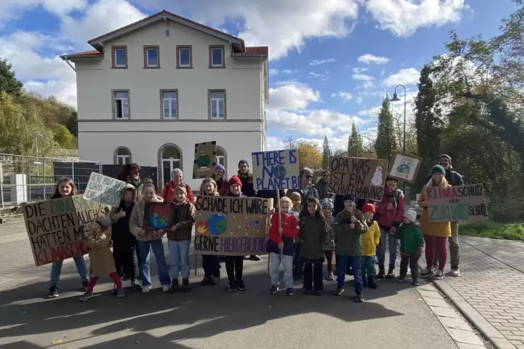 Mit Plakaten und Parolen: Zusammen wollen Kinder, Eltern und Gro&szlig;eltern ihre Mitmenschen auf den Klimawandel und seine Auswirkun