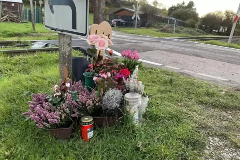 Blumen und Kerzen erinnern am unbeschrankten Bahnübergang an den tödlichen Unfall vor drei Monaten.