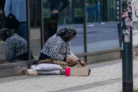 Mit Klingelbecher und Pappschild: Am Mittwochmittag bettelt eine Frau in der Kaiserslauterer City, vor der Mall, um Geld – angeb