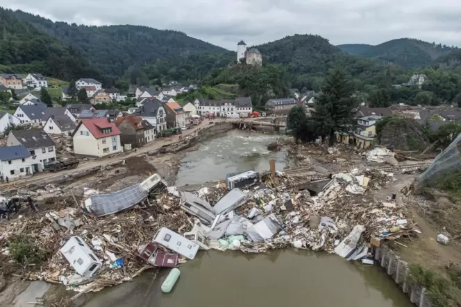 Meterhoch türmen sich wenige Tage nach der Flutkatastrophe Wohnwagen, Gastanks, Bäume und Schrott an einer Brücke über die Ahr i