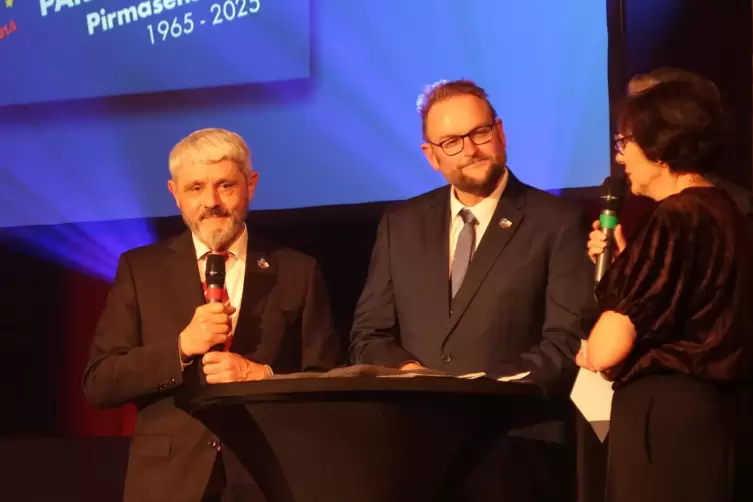 Der ehemalige OB von Pirmasens, Bernhard Matheis, und sein Nachfolger Markus Zwick weisen mithilfe einer Dolmetscherin auf die B