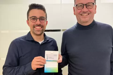 Im Wirtschaftsraum Kandel gibt es statt Papier jetzt die digitale Gutscheinkarte. Dominik Ehl und Dieter Frey halten ein Exempla