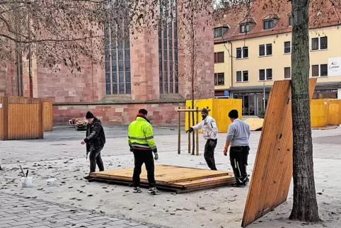 Aufbau der Stände für den Weihnachtsmarkt auf dem Alexanderplatz: Eine der neu gepflanzten Erlen muss kurz eine Wand einer Bude 