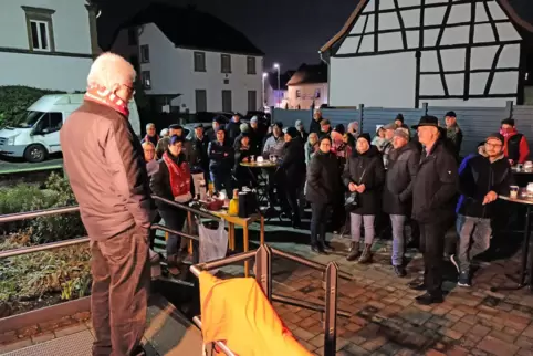 Beim ersten Adventsfenster in Niederauerbach vor dem protestantischen Gemeindehaus, trägt Willi Richter von den Naturfreunden Ge