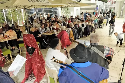 Vorweihnachtlicher Gesang in der Hallplatz-Galerie: An der Gitarre sind Werner Strass, Udo Lang (mit Hut) und Berni Düker (von l Vorweihnachtlicher Gesang in der Hallplatz-Galerie: An der Gitarre sind Werner Strass, Udo Lang (mit Hut) und Berni Düker (von l