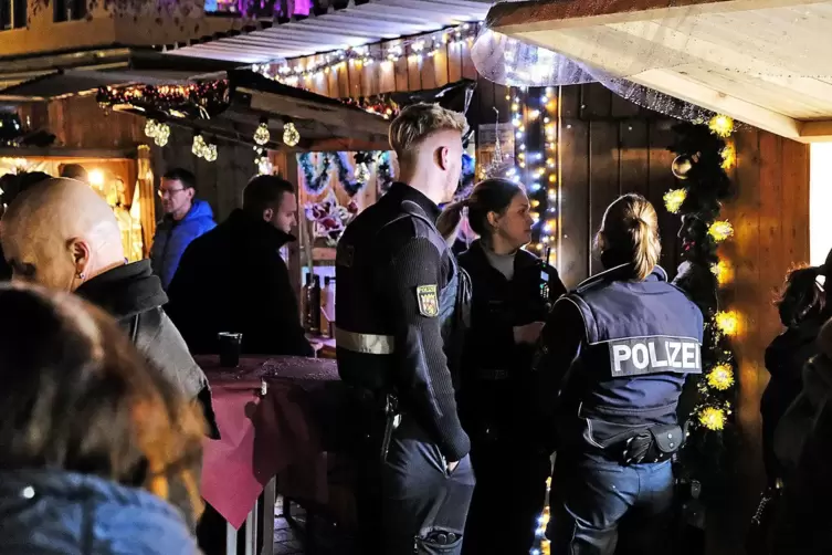 Polizisten befragen die bestohlene Betreiberin des Langos-Standes nach dem Kassendiebstahl. 