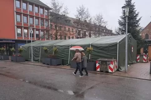 In dem Zelt der Bundeswehr auf dem Weihnachtsmarkt verkaufen Soldaten Erbensuppe. Davor sind am Samstag zwei Soldaten mit Waffen