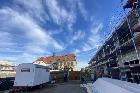 Das alte Schulgebäude in der Mitte im Hintergrund. Rechts steht der Rohbau des Kita-Komplexes und links der des Schulerweiterung