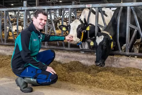 Neuer Chef im Kuhstall: Jason Hayer mit den Tieren im Stall. Er setzt auf eine Zukunft, in der Kühe und Klimaschutz Hand in Hand Neuer Chef im Kuhstall: Jason Hayer mit den Tieren im Stall. Er setzt auf eine Zukunft, in der Kühe und Klimaschutz Hand in Hand