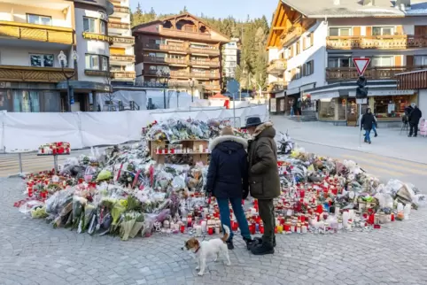 Blumen und Kerzen stehen zum Gedenken an die Opfer des Brandes in der Bar und Lounge "Le Constellation". Am Neujahrstag kamen im Blumen und Kerzen stehen zum Gedenken an die Opfer des Brandes in der Bar und Lounge "Le Constellation". Am Neujahrstag kamen im