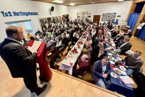  Bürgermeister Patrick Schmitt spricht vor vollem Haus im Sportlerheim des TuS Hertlingshausen.