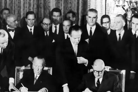Der französische Staatspräsident Charles de Gaulle (rechts) und der deutsche Bundeskanzler Konrad Adenauer unterzeichnen am 22.1