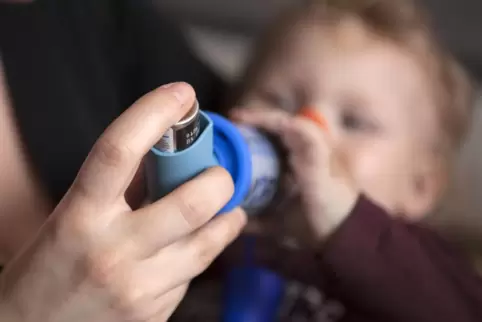 Ein kleines Kind mit Asthma erhält mithilfe eines Dosieraerosols seine Inhalationsmedikation. Frühe und fachgerechte Behandlung Ein kleines Kind mit Asthma erhält mithilfe eines Dosieraerosols seine Inhalationsmedikation. Frühe und fachgerechte Behandlung