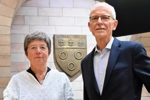 Dagmar Fries und Martin Meister vor dem Stadtwappen der Partnerstadt Mâcon im Ratsaal. 