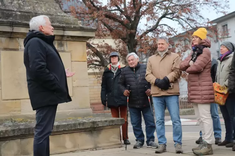Pierre Amblard mit einer Gruppe Neugieriger vor dem Franzosendenkmal. 