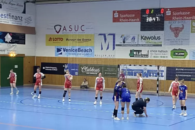 Leonie Kripp ( hockend) wischt im Spiel den Hallenboden.
