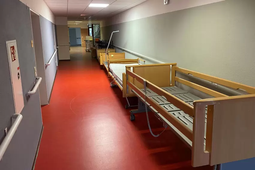 Setting für einen Horrorfilm: leerer Altenheimflur mit Betten.