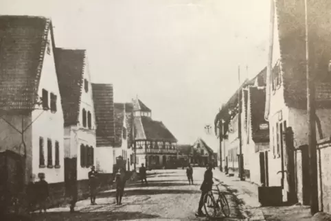 Die Speyerer Straße in Dudenhofen vor dem Ersten Weltkrieg: Hinten links „Zum goldenen Lamm“, rechts „Zum schwarzen Adler“. 