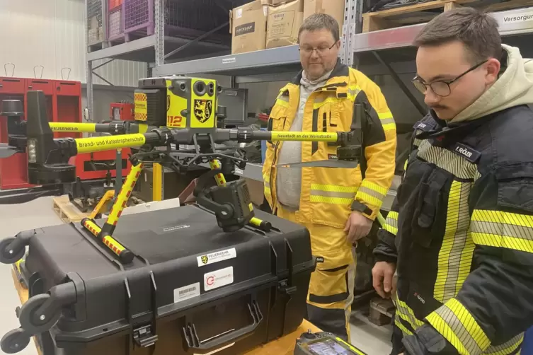 Vor dem Start montieren Felipe R&ouml;&szlig;ler (rechts) und Dirk Eckel Kamera und Scheinwerfer an der Drohne. 