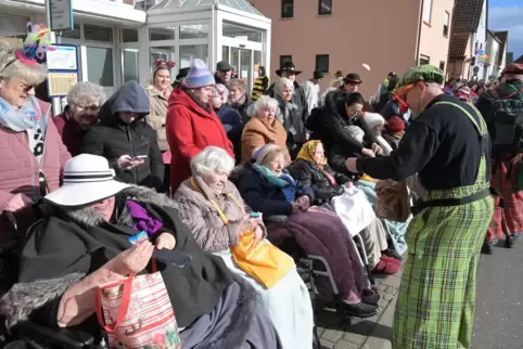 Sitzen dick eingepackt am Straßenrand: Senioren und Seniorinnen beim Fasnachtsumzug in Waldsee. 