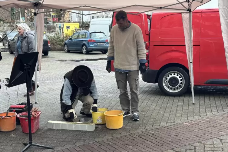 K&uuml;nstler Gunter Demnig l&auml;sst die Stolperschwelle in das Stra&szlig;enpflaster ein. 