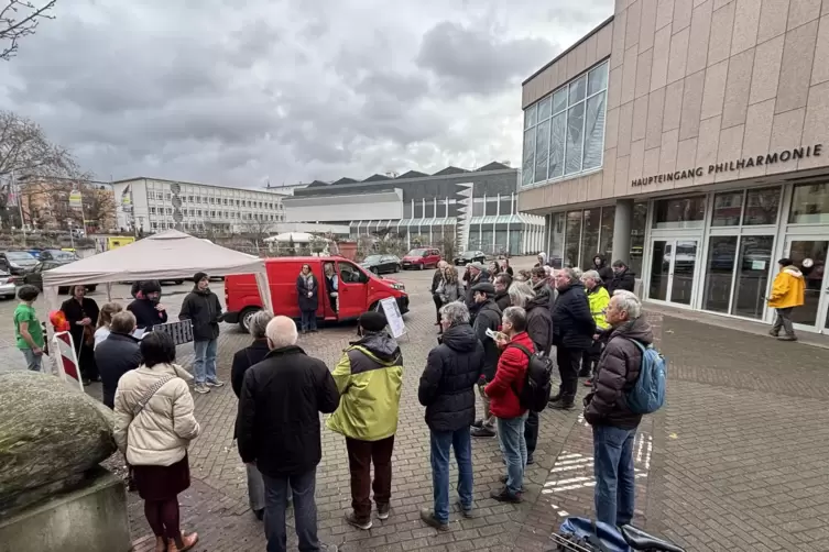 Auf dem Vorplatz der Philharmonie versammeln sich Menschen mit Rosen, um der Verlegung beizuwohnen. 