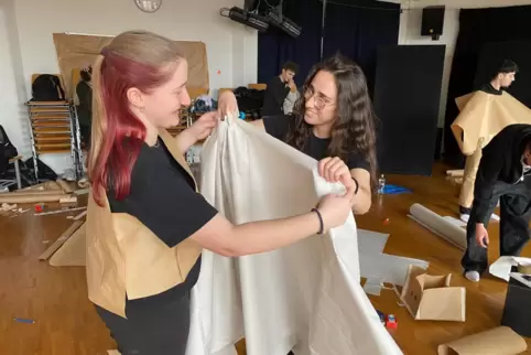 Rebecca Schuster (links) und Karla Yildiz stellen aus Zeitungspapier ein Theaterkostüm her, das typisch für die Antike ist. 