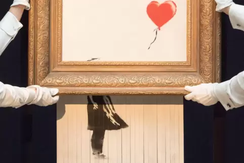 Mitarbeiter von Sotheby’s präsentieren am 12. Oktober 2018 Banksys „Love is in the Bin“ in London. Ursprünglich hieß das Werk „G Mitarbeiter von Sotheby’s präsentieren am 12. Oktober 2018 Banksys „Love is in the Bin“ in London. Ursprünglich hieß das Werk „G