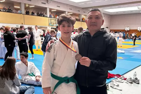 Bronzemedaillengewinner Livian Hermann mit HHG-Trainer Aydin Kempirbaev am Mattenrand in Backnang. 