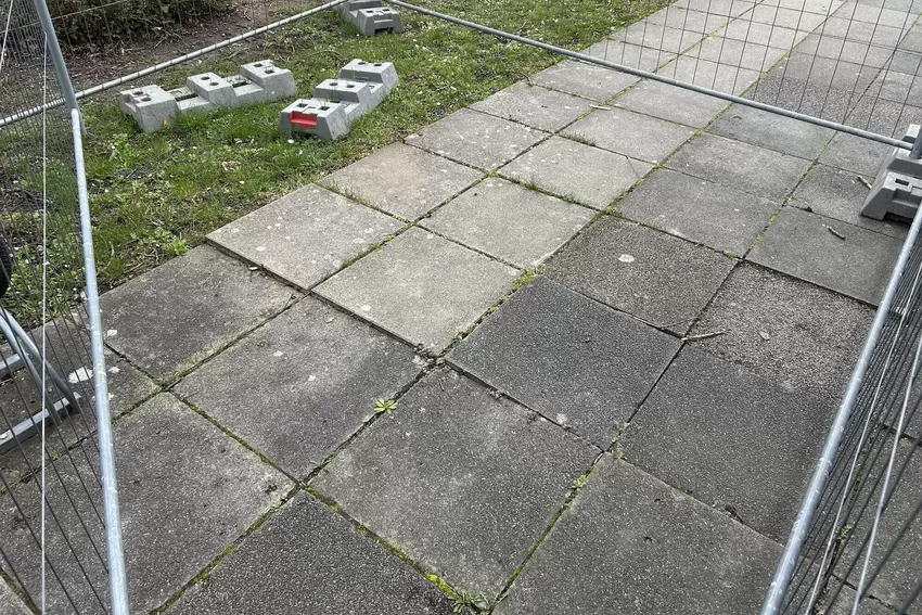 Vor der Schule haben Wurzeln einige Platten angehoben. Der Bereich wurde abgesperrt, dass kein Kind stolpert.