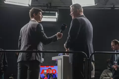 Der Wahlsieger Gordon Schnieder (CDU) gibt am Sonntagabend ein Interview. Auf dem Monitor in der Bildmitte: der unterlegene Mini