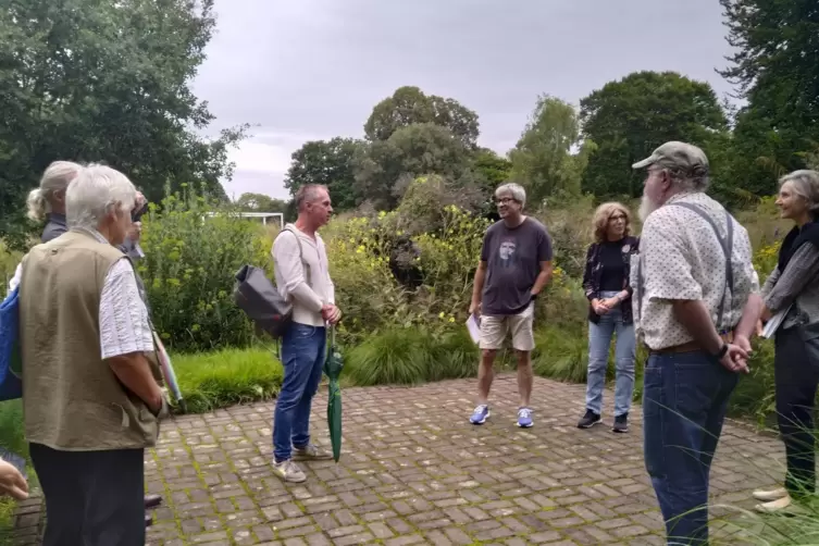 Harald Sauer (Mitte, mit Regenschirm; bei einer F&uuml;hrung im Ebertpark in Ludwigshafen) will Menschen f&uuml;r Pflanzen begeistern.