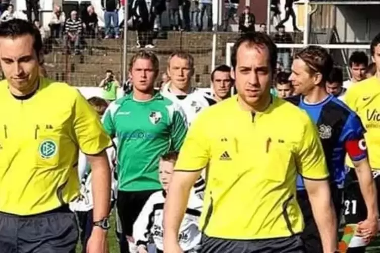 Sorg und Stumpf (links hinterm Linienrichter) laufen hintereinander zum Pokalspiel gegen den 1. FC Saarbr&uuml;cken ins Ellenfeld ein