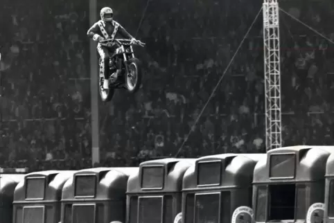 1975 versucht Evel Knievel im ausverkauften Londoner Wembley-Stadion, mit seinem Motorrad über 13 Busse zu springen. Mit 145 km/