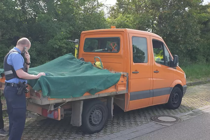 Polizeikommissar Torben Krämer stellt fest, dass eine Rüttelplatte auf einem Klein-Lkw nicht mit einem Spanngurt befestigt ist.