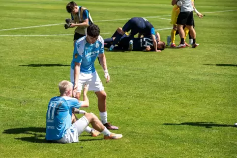 Während die Mainzer Spieler feiern, hilft Oskar Prokopchuk seinem Teamkollegen Marc Ehrhart nach der Niederlage auf die Beine. 