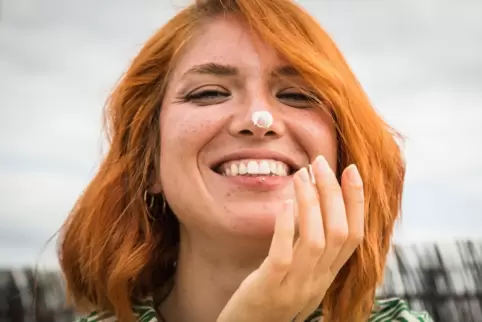 Frau trägt Sonnencreme auf