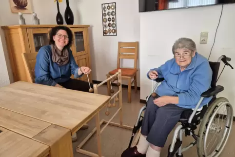 Isabell Zimmer, Leiterin des Seniorenzentrums „Haus Königsland“ in Wolfstein, versucht sich mit Bewohnerin Karin Bohlander an ei