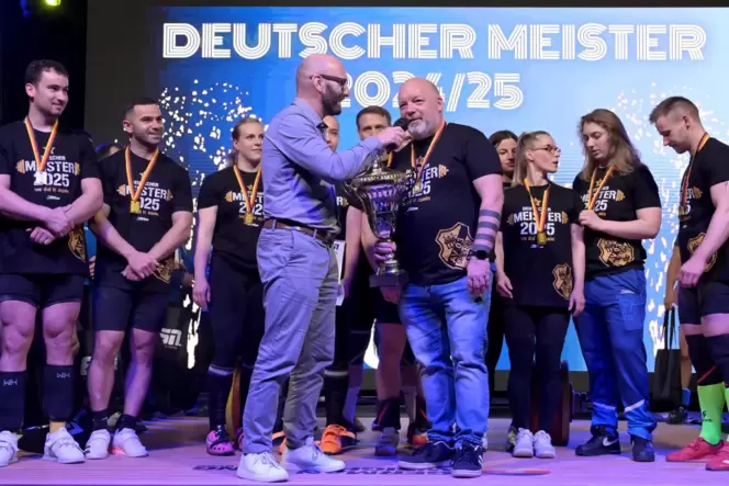 Beim Rekordversuch dabei: Frank Hinderberger (mit Pokal) von AV 03 Speyer und seine Meister-Gewichtheber.