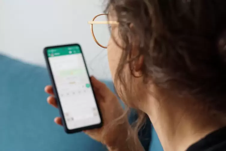 Eine junge Frau liest eine Nachricht auf einem Smartphone