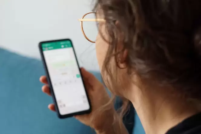 Eine junge Frau liest eine Nachricht auf einem Smartphone