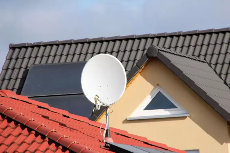 Eine Satellitensch&uuml;ssel auf einem Hausdach