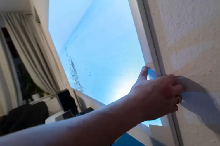 Ein Mann h&auml;ngt eine Beamer-Leinwand auf