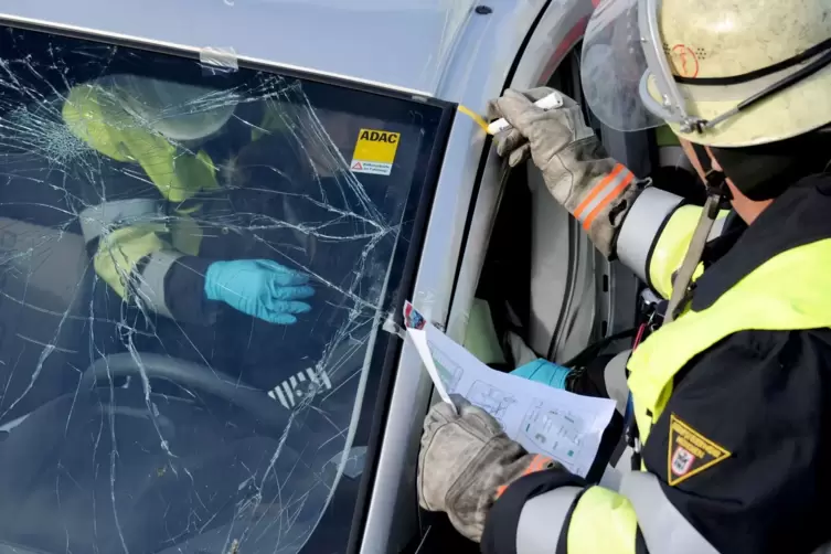 Rettungskräfte bei der Bergung einer Person aus einem Auto