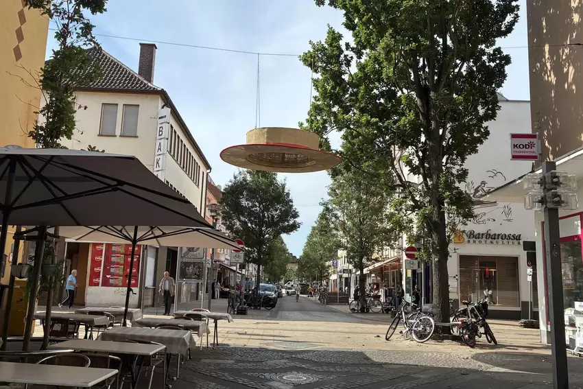 ...als auch in der Speyerer Straße hängen die Strohhüte über den Köpfen der Passanten.